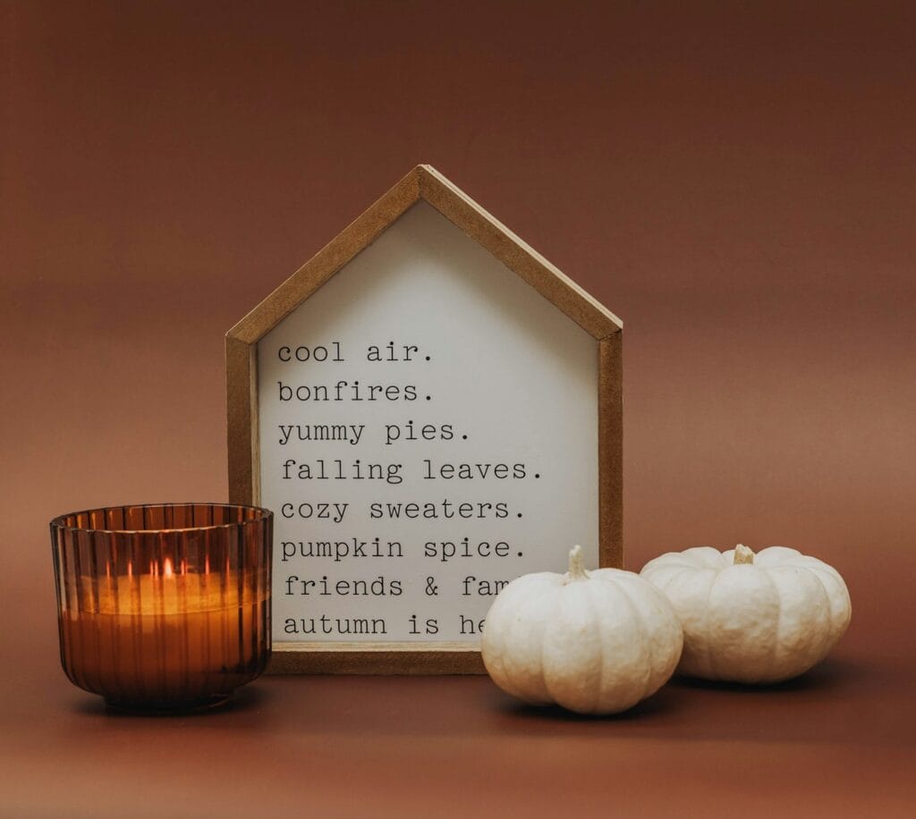 a candle and some white pumpkins on a table