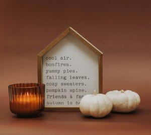 a candle and some white pumpkins on a table