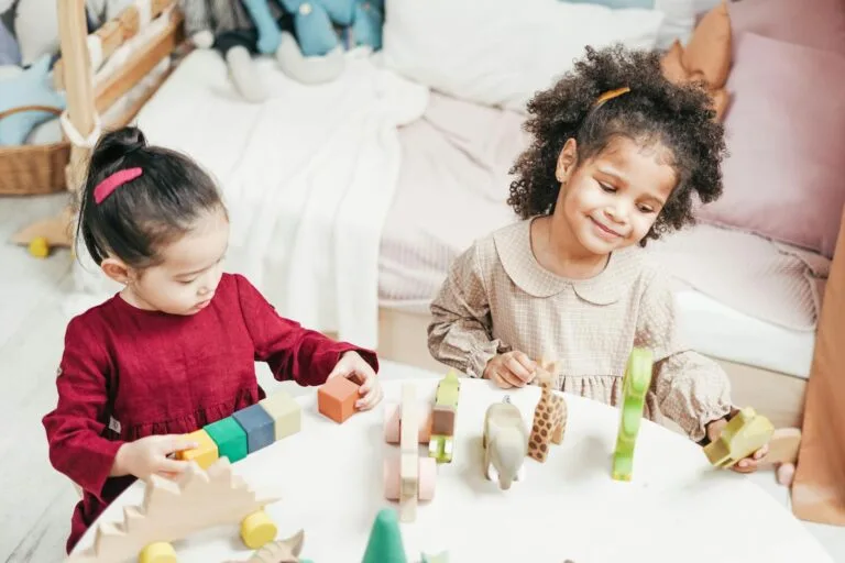 Two children happily play with wooden toys indoors, fostering creativity and joy.
