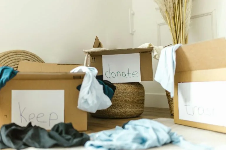 Cardboard boxes labeled keep, donate, and trash for effective home organization.